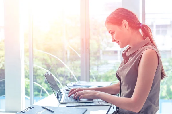 Mädchen tippen am Laptop Computer Geschäft in Bürofenster Porträt Seitenansicht — Stockfoto