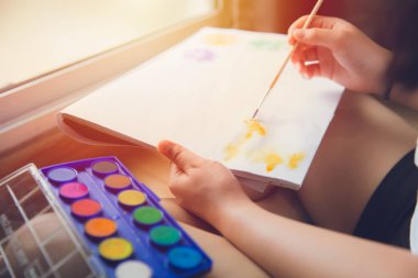 çocuklar el evde hobi için su rengi boyama çizmek için boya fırçası kullanarak uygulama zevk