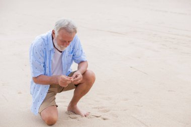 elder man palaeontologist discovery to find meaning of life concept he found something in the beach or analysis seashells clipart