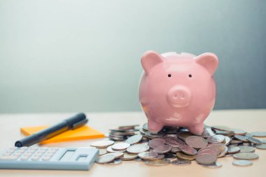 Kişisel hesap para tasarrufu kavramı için sikke notu kağıt ve hesap makinesi ile Piggy banka