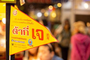 Tayland 'da Vejetaryen Festivali (J Festivali) Alışveriş Merkezi' nde sebze tezgahı dekorasyonunda sarı bayrak ve bir sürü insan Tayland ve Çin yemeği. 29 Eylül 2019. Chiang Mai, Tayland.