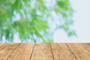 Şablon için ahşap masa önü ile yeşil doğa beyaz görünüm ürünleri arka planı maketi.