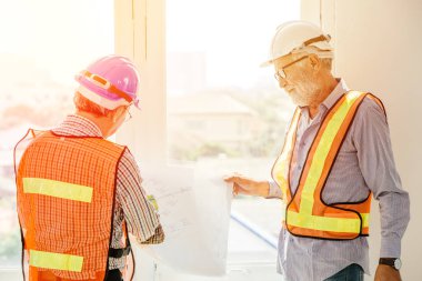 İnşaat sahasında inşaat planıyla ilgili danışmanlık yapan iki mühendis.