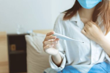 Sıcaklık ölçer kullanan insanlar Coronavirus enfeksiyonuna grip ve korku tanısı koymak için vücut ısısını ölçer..
