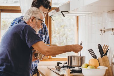 Mutlu yaşlı adam, oğluyla mutfak odasında yemek yapmayı seviyor. Evde kalıp, boş zaman aktivitesi ve insanların yaşam tarzı için..