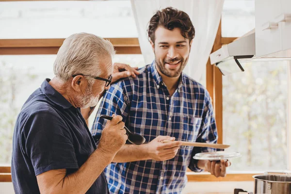 Mutlu kıdemli yaşlı adam, evde kalıp eğlenmek ve insanların yaşam tarzlarını izlemek için mutfakta ailesiyle yemek pişirmekten hoşlanıyor..