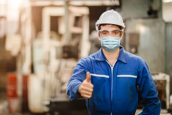 Worker wearing face shield or disposable face mask during working service in factory to prevent Coronavirus(Covid-19) or Air dust pollution in factory.