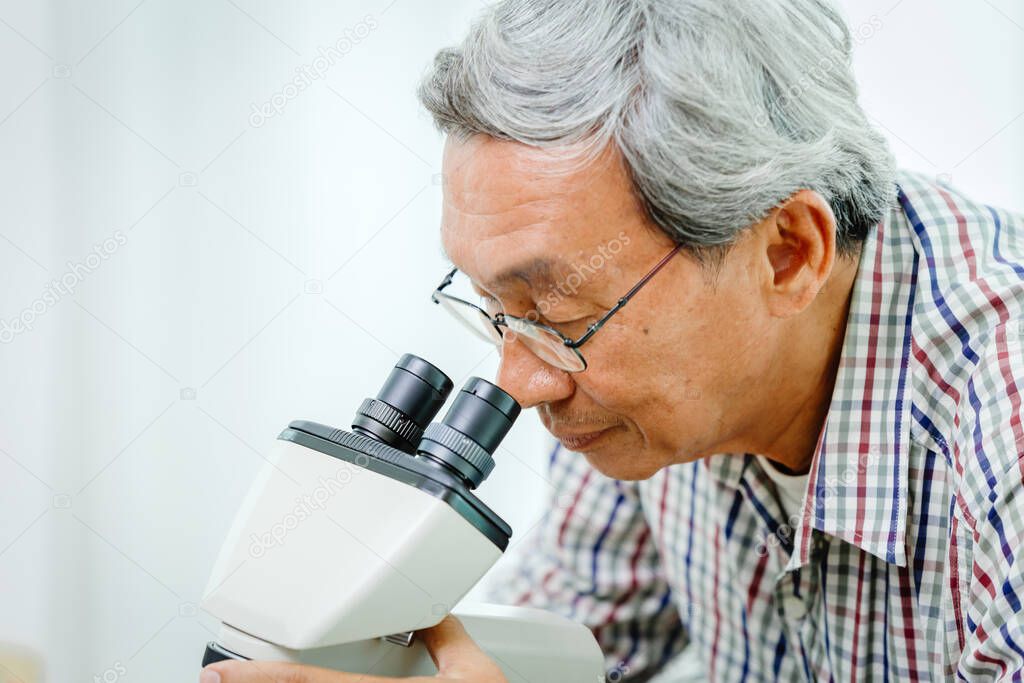 Asian Chinese doctor looking at microscope for Virus medical science and research in hospital lab
