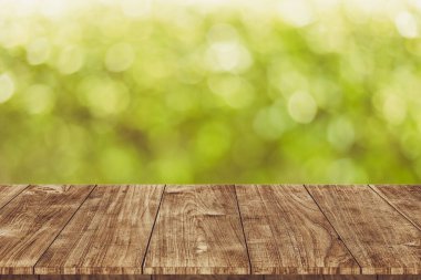Doğa ürünleri reklam montajı şablonu için ahşap masa üstü boş bulanık yeşil bokeh vintage arka plan.