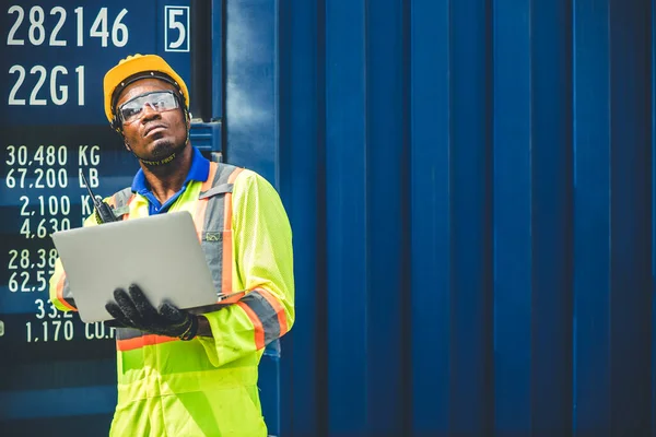 在物流运输部门工作的非洲黑人工人使用笔记本电脑 在港口装卸集装箱 供今后进口货物的领班看上去很高 — 图库照片