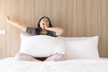 Tembel kadın sabah uyandıktan sonra esnedi ve gerildi..