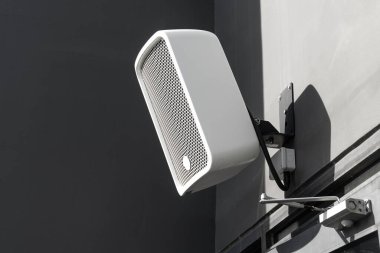 Dış mekan müzik sistemi ses sistemi için balkon duvarına kurulmuş açık hava hoparlör sistemi. Bar ve restoran binasının dışındaki park alanı için.