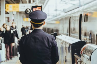 Tren istasyonunda çalışan Japon Demiryolu Subayı tren ve gezginler için metro istasyonu güvenliği operasyonu