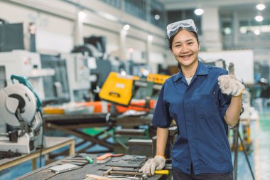 Mutlu gülümseyen mühendis, modern metal atölyesi fabrikasında portre çiziyor.