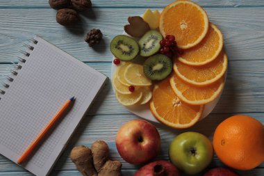 Meyveler tabak kivi, portakal, limon, nar ve haplar üzerinde yatıyor.