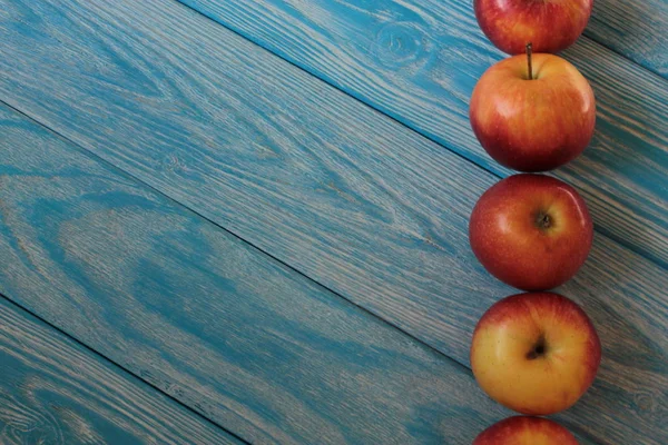 Rote Äpfel Liegen Auf Blauem Holzgrund — Stockfoto