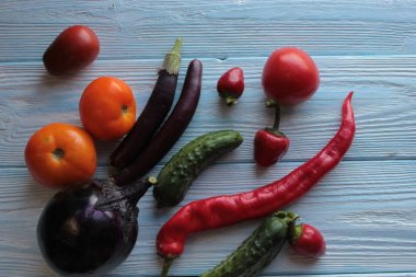 Domates, patlıcan, biber ve salatalık ahşap bir arka plan üzerinde yalan.