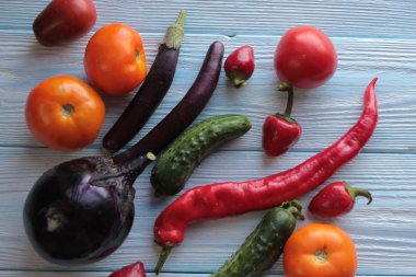 Domates, patlıcan, biber ve salatalık ahşap bir arka plan üzerinde yalan.