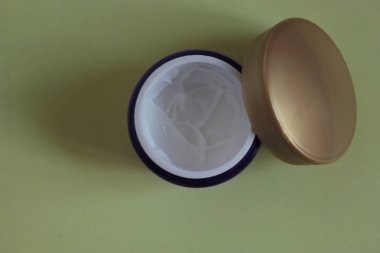 Sarı bir arka plan üzerinde mor bir kavanozda Kozmetik krem.