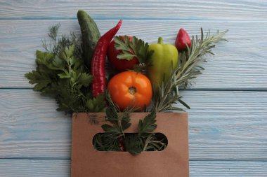 Sebzeli kağıt bir paket ahşap bir arka plan üzerinde yatıyor.