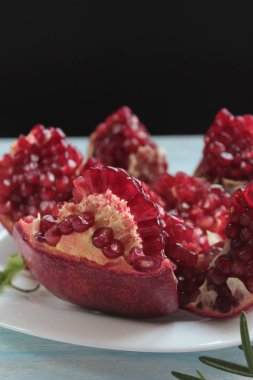 Beyaz bir tabakta kırmızı bir nar yatıyor..
