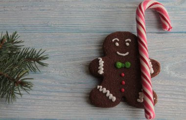 Karamel bastonlu zencefilli ekmek adam ve tahta bir yüzey üzerinde ladin dalı..