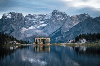 Misurina Gölü ile büyük bina Enstitüsü Pius XII çalılar batımında aracılığıyla bir bakış. Dolomites, İtalya.
