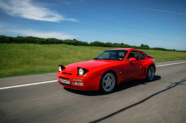 Minsk, Beyaz Rusya - 26 Mayıs 2018: Kırmızı eski model Porsche 944 spor motion blur efekti ile yol boyunca hız araba.