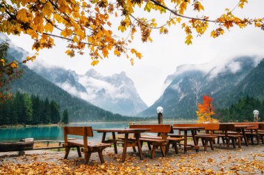Dobbiaco göl veya Toblacher Dolomites ile ahşap masa ve banklar açık kafe restoran Güz
