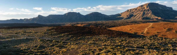 Mountain landscape with road, volcanic lava rocks and desert with Mounts Guajara, Pasajiron and Majua, Teide National Park, Tenerife, Canary Islands