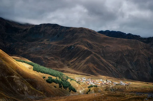 Wioska na wzgórzu gór Wielkokaukaskich, Kazbegi, Gruzja. — Zdjęcie stockowe