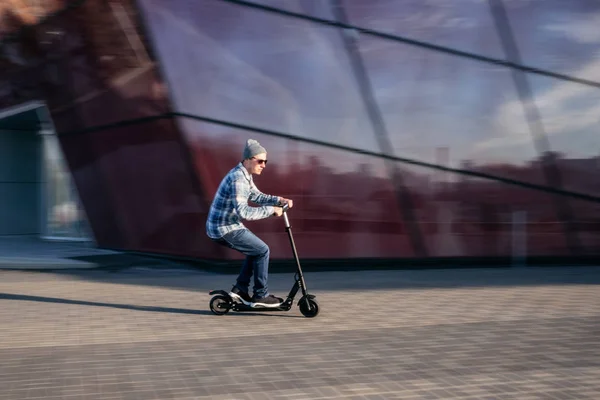 Молодий чоловік на електричному скутері на вулиці — стокове фото