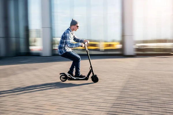 Sokakta elektrikli scooter üzerinde genç adam — Stok fotoğraf