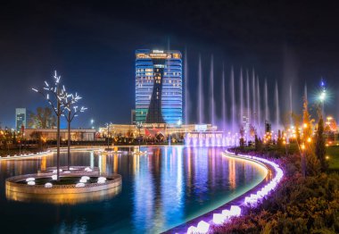 Taşkent, Özbekistan - 30 Ekim 2019: Yeni Taşkent Şehir Parkı 'ndaki gölde yansıyan güzel bir dans çeşmesi