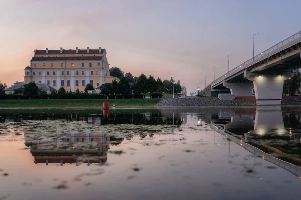 ベルラーシの日没時にピンクにイエズス会の大学の建物と橋 ストックフォト