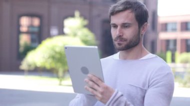 Yakışıklı adam Internet tarama dışında ayakta iken Tablet bilgisayarda