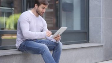 Heyecanlı adam merdivenlerde oturan laptop başarı kutluyor