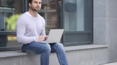 Dalgın yakışıklı adam Laptop oturma pencere yakınındaki üzerinde çalışırken düşünme