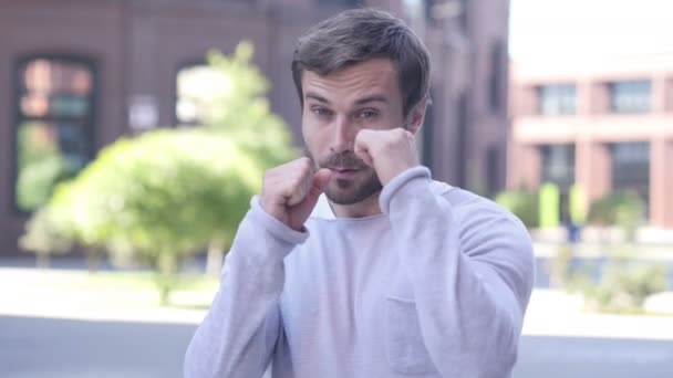 Walki gest przez agresywne przystojny mężczyzna, stojący na zewnątrz — Wideo stockowe