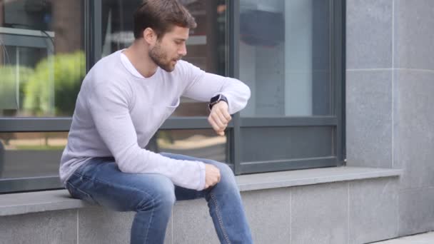 Čekání pohledný muž, sledování času na hodinky — Stock video