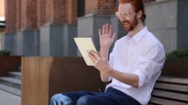 Online görüntülü sohbet tarafından tasarımcı bankta oturan tablet