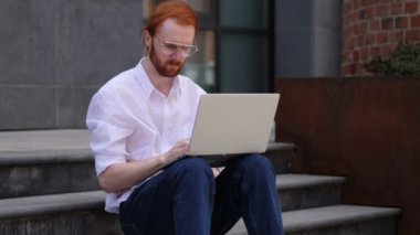 Laptop oturma pencere yakınındaki üzerinde çalışırken dalgın tasarımcı düşünme
