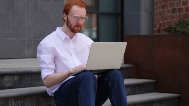 Aufgeregter Mann Feiert Erfolg Auf Laptop Während Auf Bürotreppe Sitzt — Stockvideo