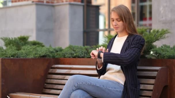 Επιχειρήσεων Γυναίκα Κάθεται Έξω Office Χρησιμοποιώντας Smartwatch Για Περιήγηση — Αρχείο Βίντεο