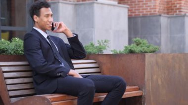 Talk, Afrika işadamı katılıyor bankta otururken ara telefon