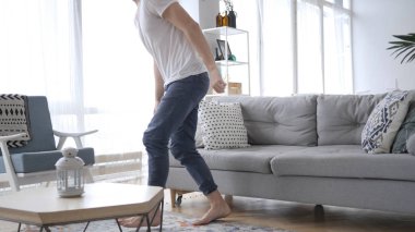 Genç adam kanepede oda bırakarak oturuyor