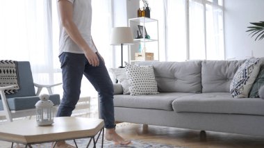 Genç adam geliyor Oda ve koltukta oturan