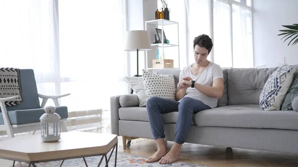 Young Man Using Smartwatch While Relaxing Sofa — Stock Photo, Image