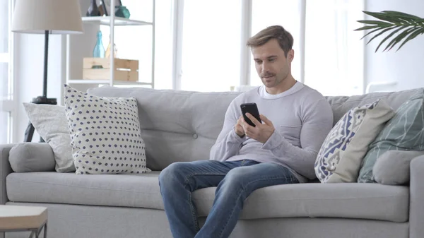 Adult Man Using Smartphone while Sitting on Couch