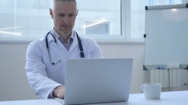 Genç doktor çalışma üstünde Laptop